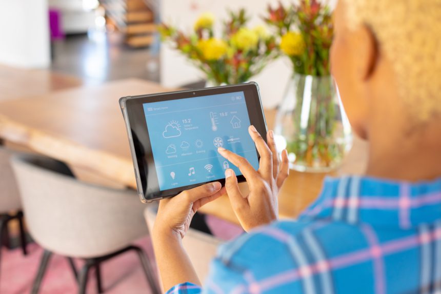 African american woman using tablet with smart home interface