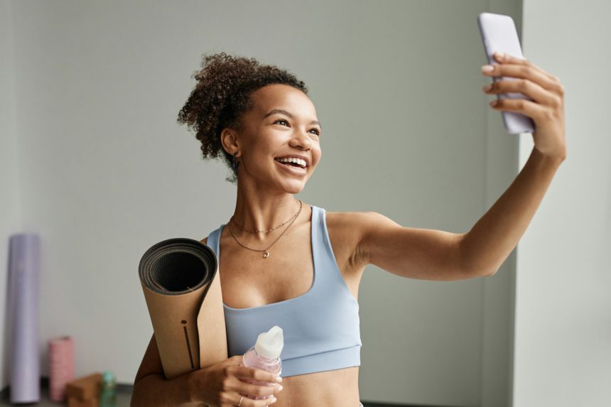 Black Young Woman Wearing Workout Taking Selfie Photo in Sports Studio