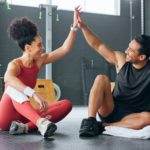 High five woman, personal trainer man for fitness goal in gym or training facility together. Succes